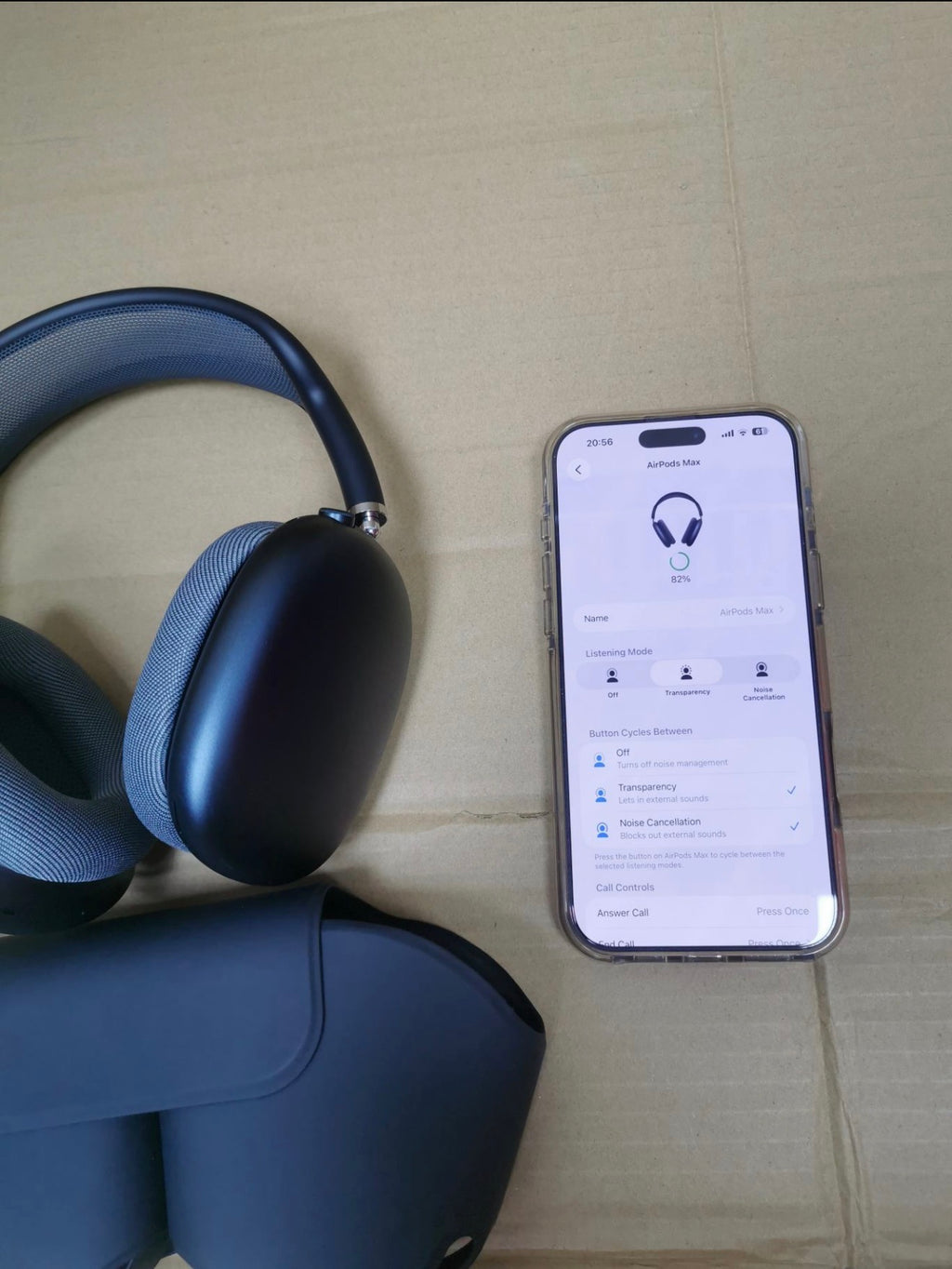 AirPods Max headphones beside a phone showing Bluetooth settings