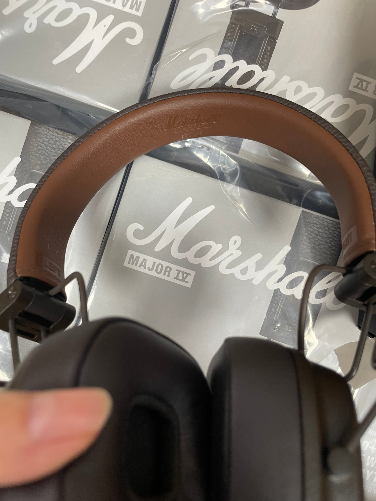 Marshall Major IV wireless headphones held over boxed products