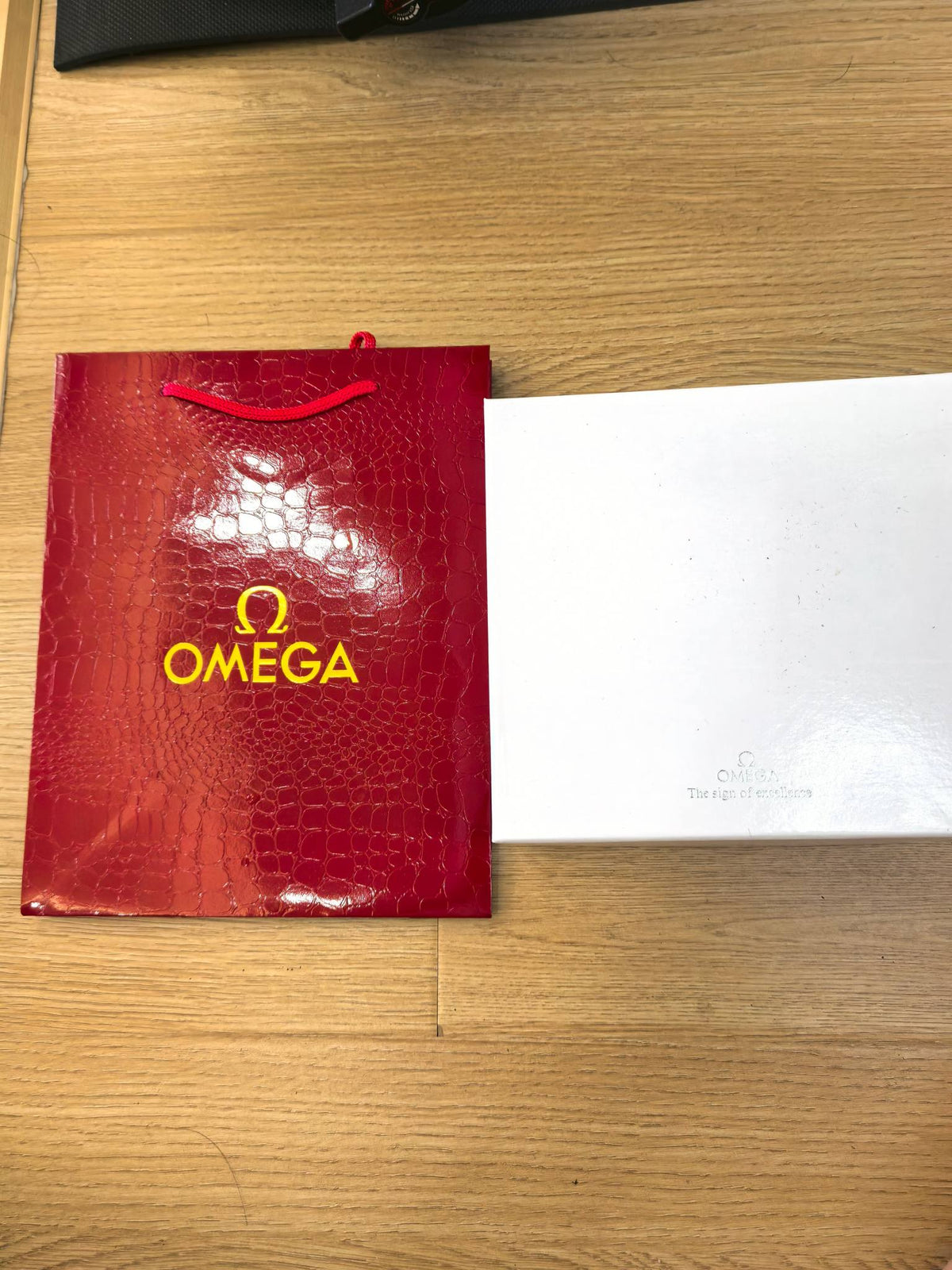 Omega Speedmaster chronograph watch with gold-tone case and green strap side view