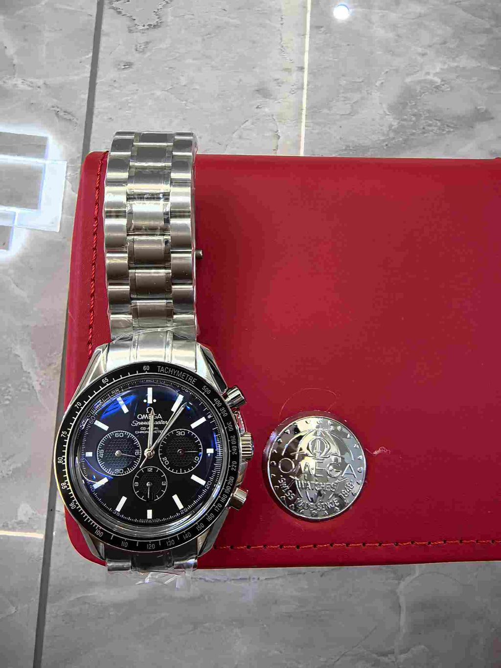 Omega Speedmaster chronograph watch in red presentation case