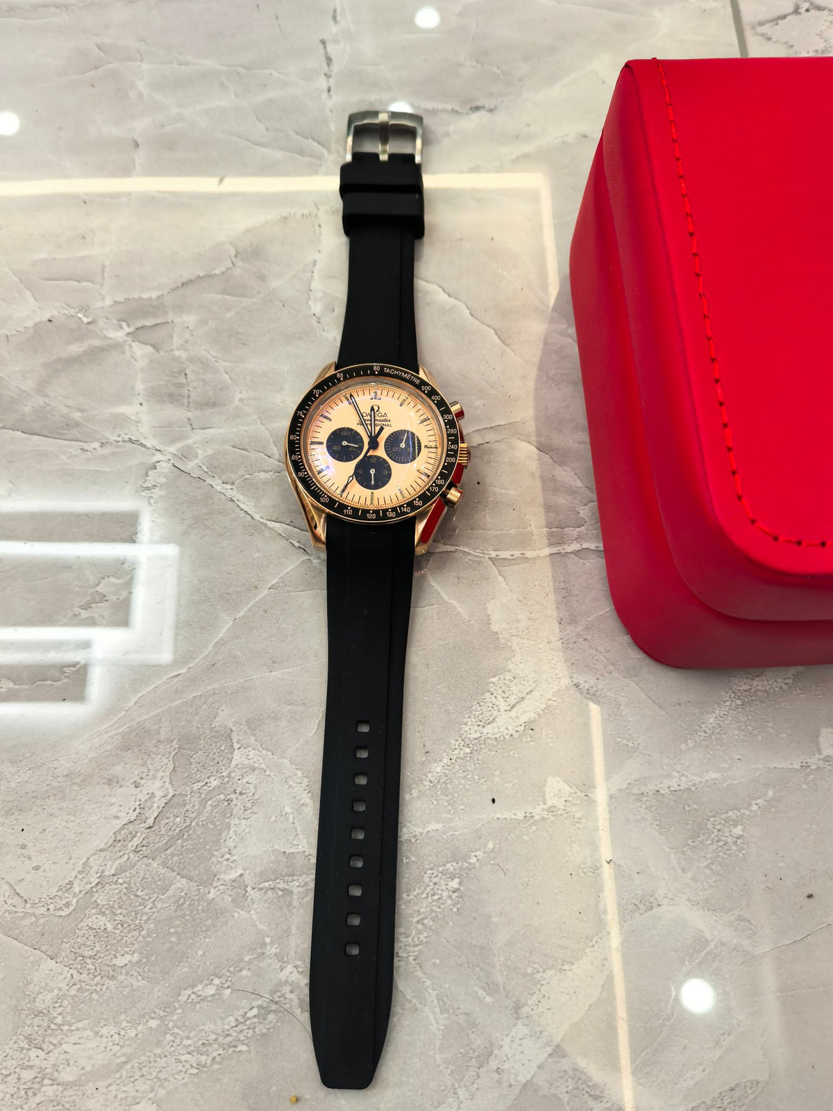 Omega Speedmaster chronograph watch with silver bracelet and blue dial on presentation case