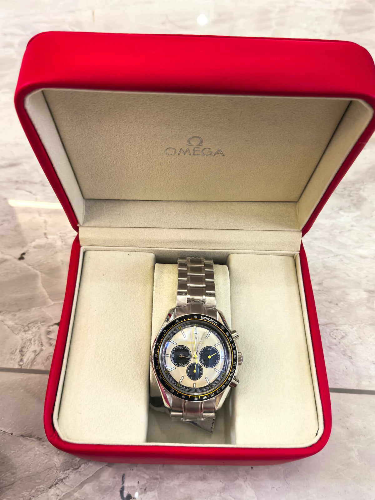 Omega Speedmaster chronograph watch with silver bracelet and blue dial