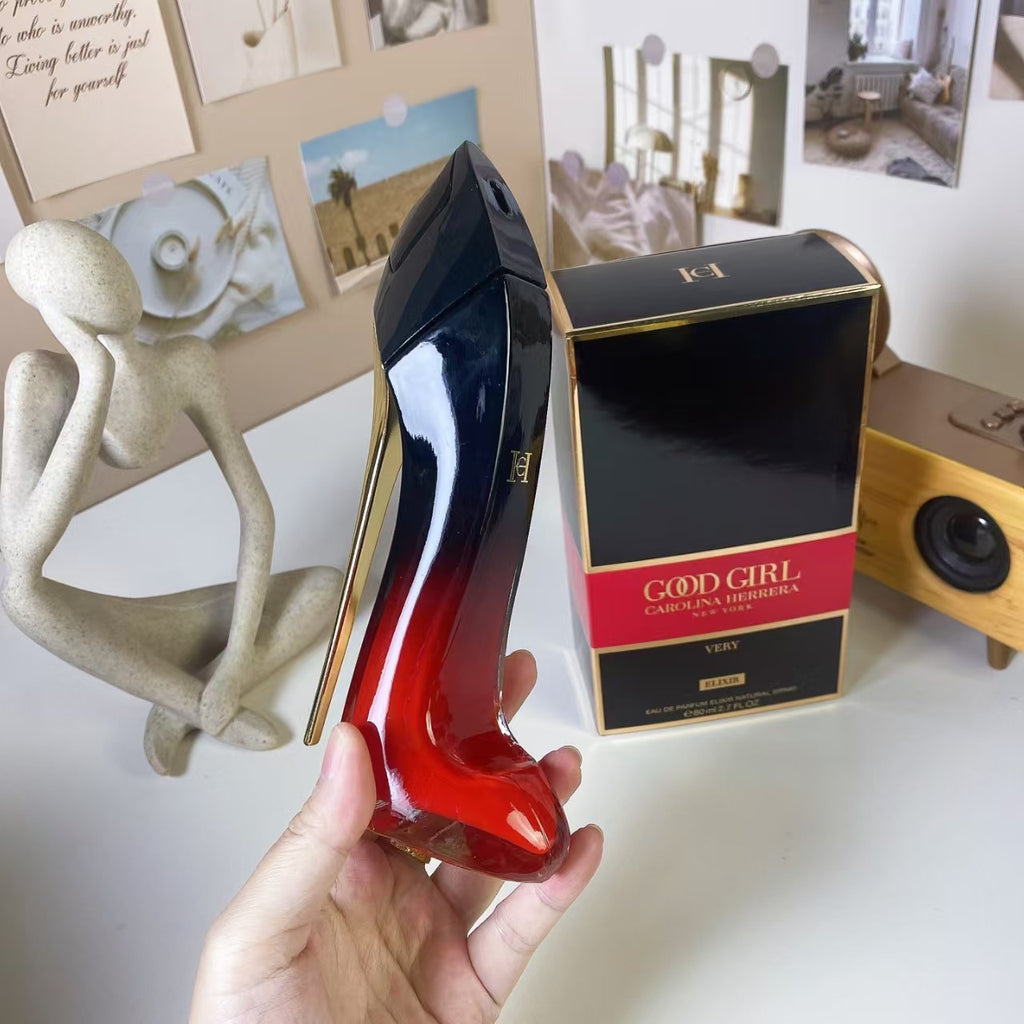 Pink and black high heel perfume bottle beside packaging