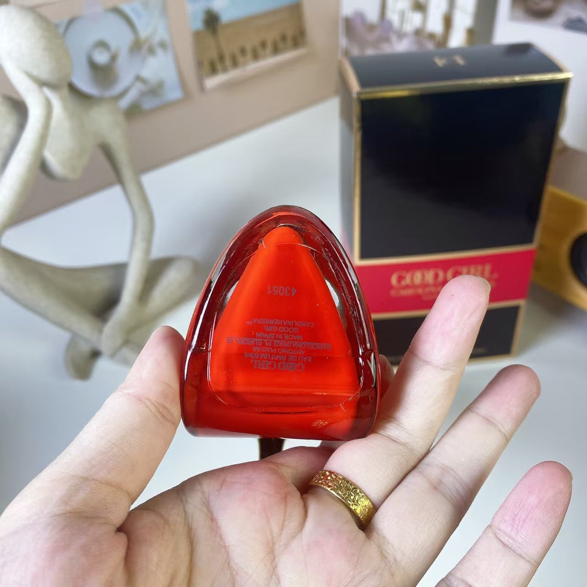 Red and black high heel perfume bottle beside packaging