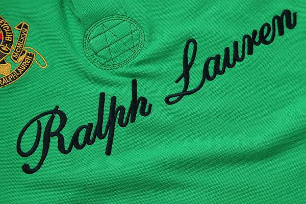 Close-up of embroidered script detail on black polo shirt